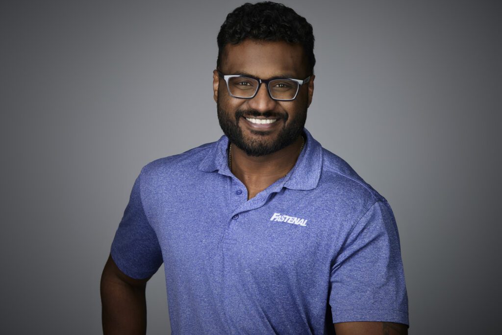 Professional headshot of a smiling man wearing glasses and a blue Fastenal polo shirt, taken in Kitchener by Trina Koster Photography